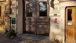 Heilpraktiker Berlin Prenzlauer Berg Hauseingang Diedenhofer Straße 4 mit dem Schild der Praxis im Bambusgarten